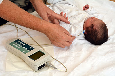 Baby having ears tested for hearing.