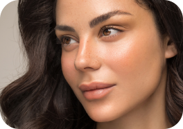 A lady's face she has long brown hair and is looking to the left