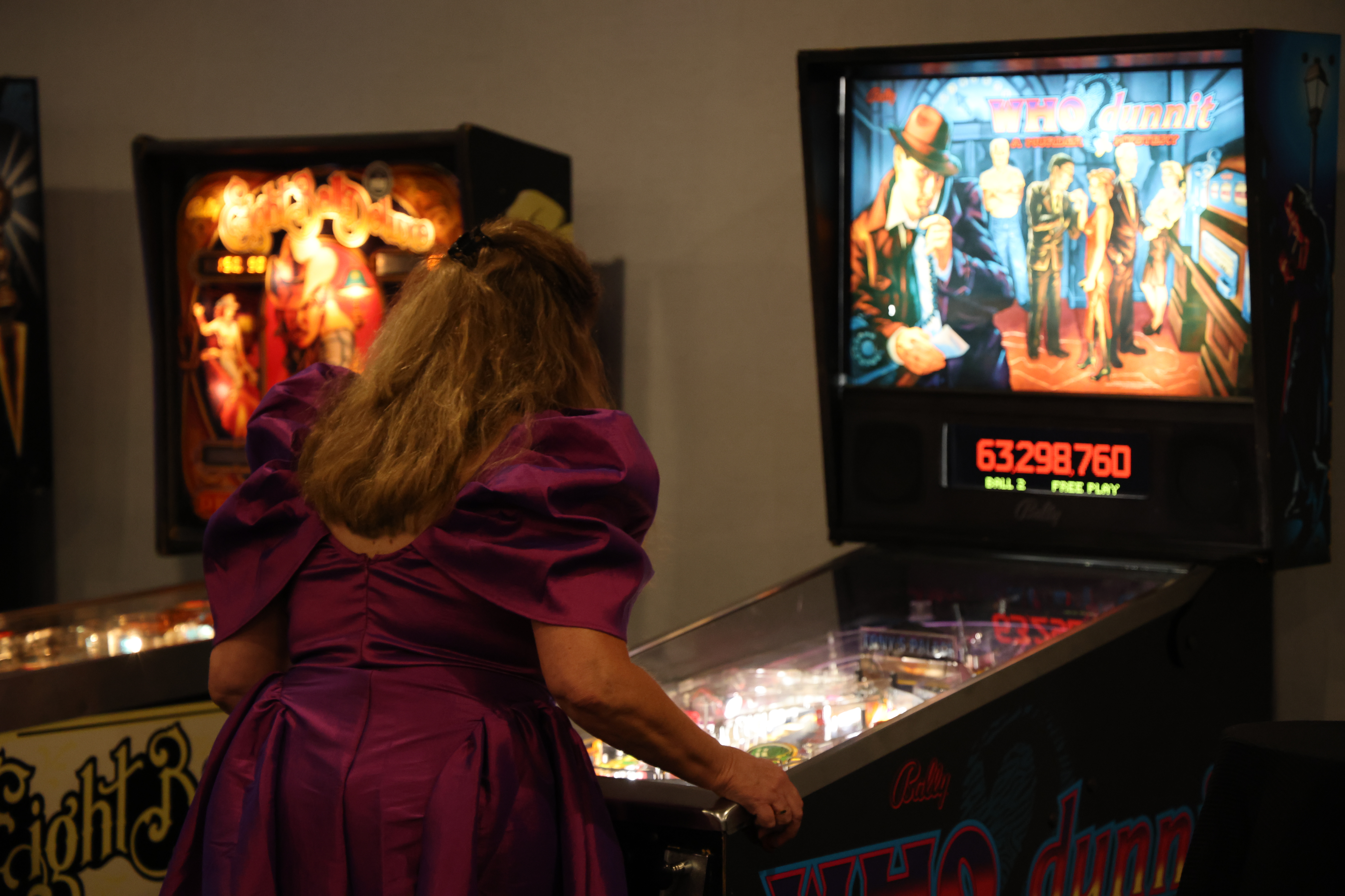 woman playing pin ball machine