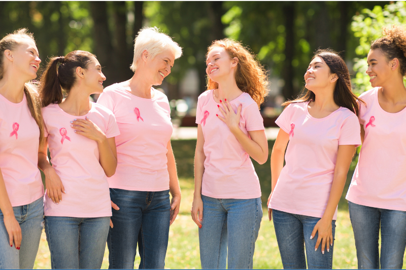 Breast Health at Every Age shows women in pink shirts standing together outdoors.