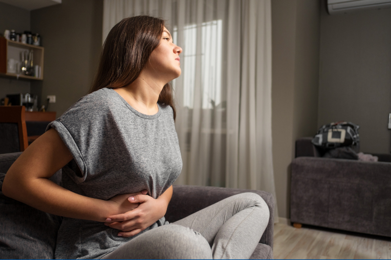 What to Expect: Laparoscopic Gallbladder Surgery and Recovery, woman holds her belly at home.