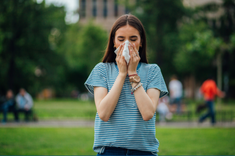 A girl on a college campus suffering from allergies