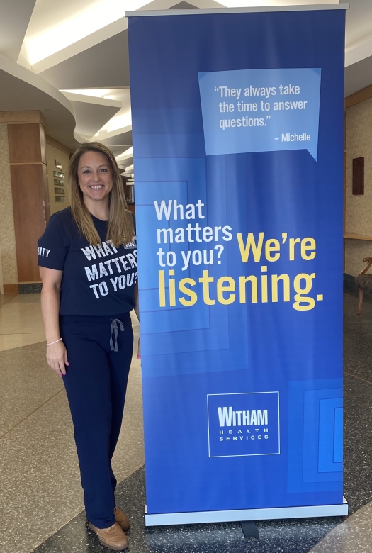 REbecca Bradley standing beside "What Matters to you?" sign