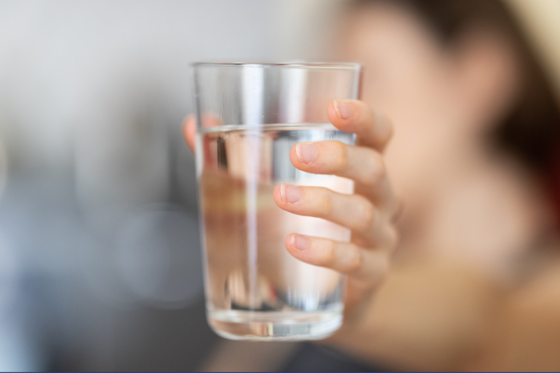 Someone holding a glass of water