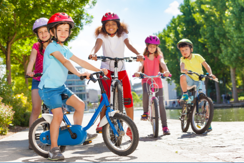 A group of kids on bikes wearing helmets