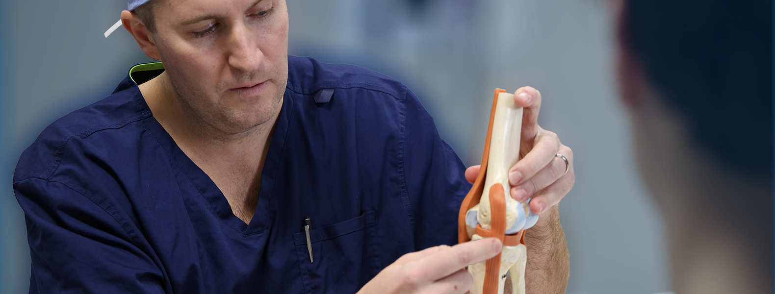 Dr. Horn shows a patient a model of a knee