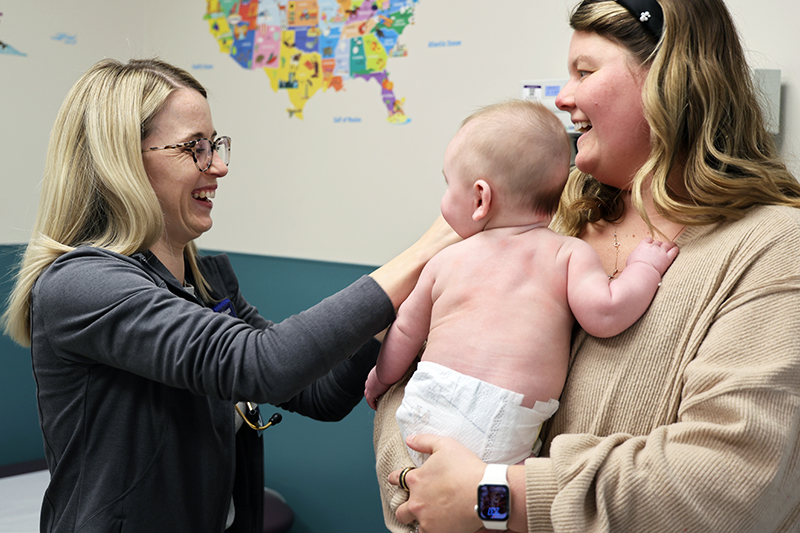 A Witham doctor examines a baby that mom is holding