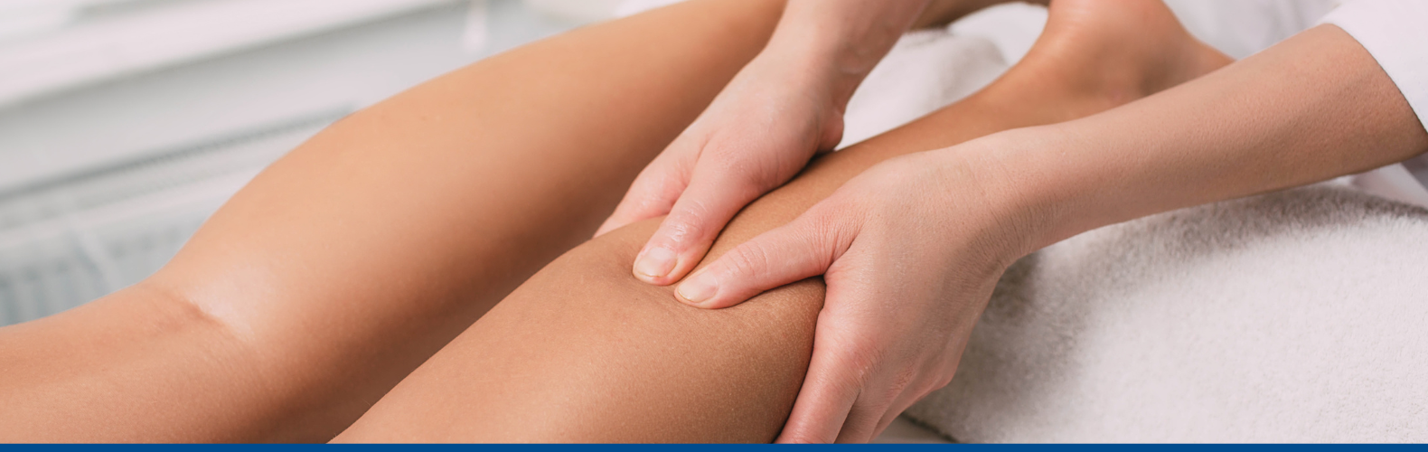 A physical therapist uses massage on a patient's leg